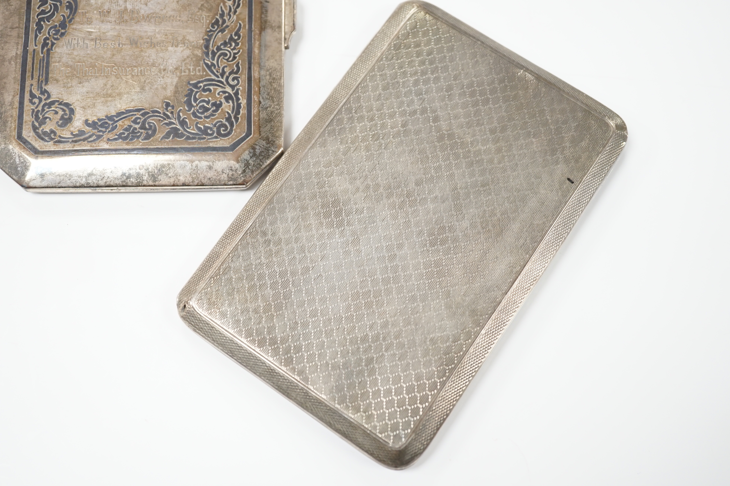 A George V engine turned silver cigarette case, 183 grams, and a Thai white metal and niello cigarette case